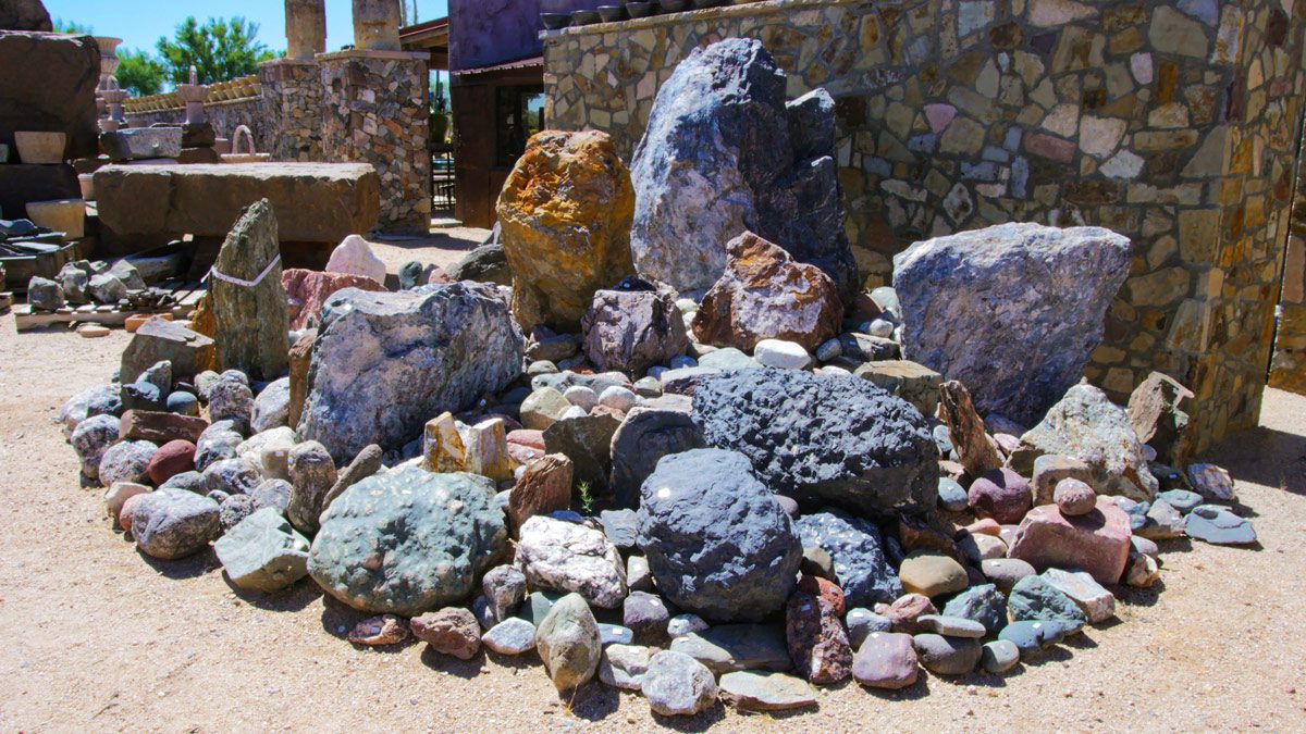 Assorted stones on sandy ground.