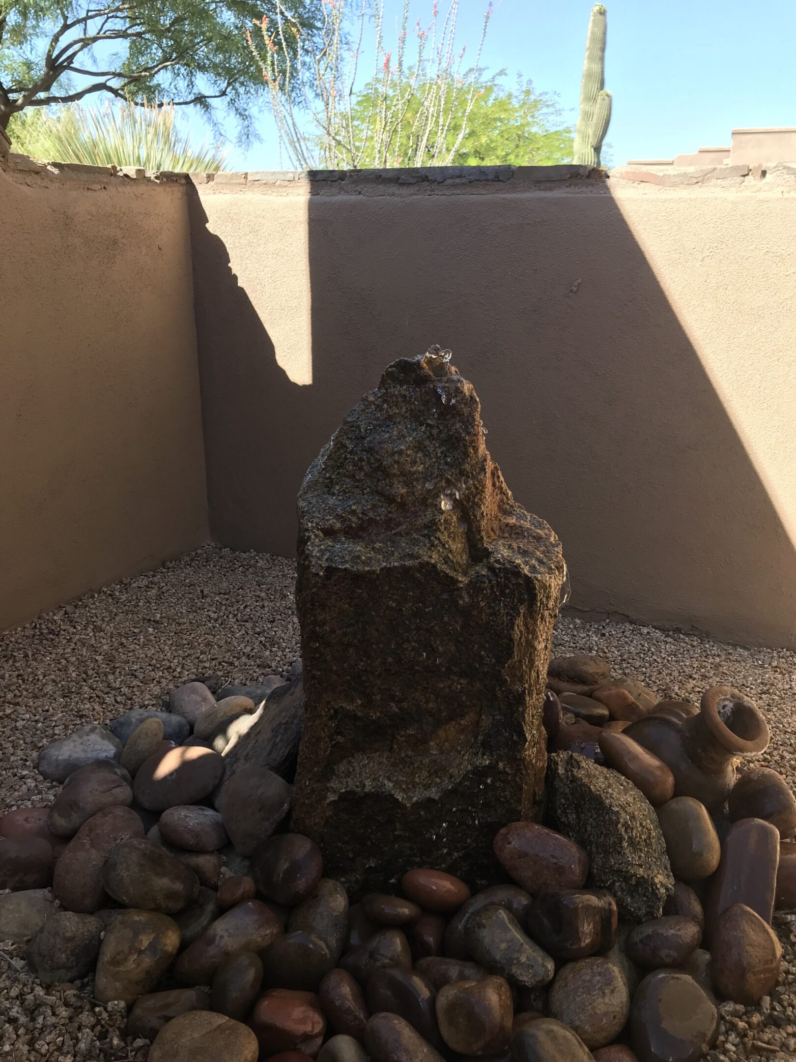 natural stone rock cored and installed as a water fountain in a backyard