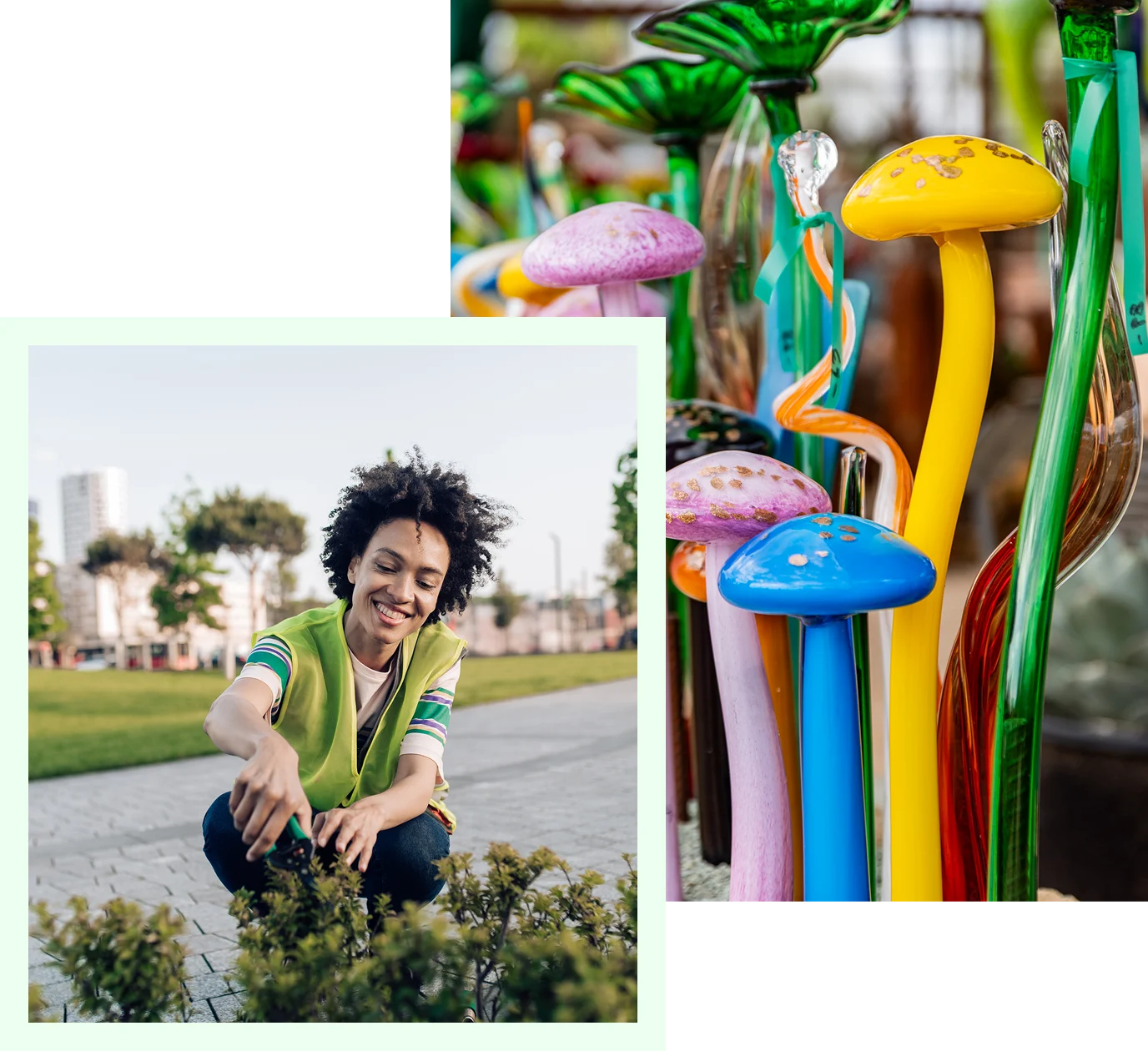 Woman kneeling down next to a bunch of colorful glass mushrooms, surrounded by plants, grass, trees, buildings
